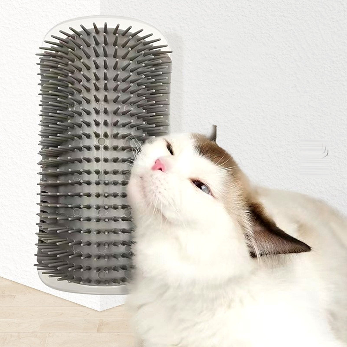 Chat qui se frotte la joue contre une brosse d'angle grise fixée sur un mur