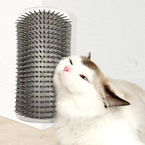 Chat qui se frotte la joue contre une brosse d'angle grise fixée sur un mur
