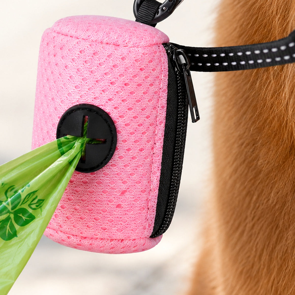Gros plan sur le distributeur rose : un sac sort par l'ouverture en croix