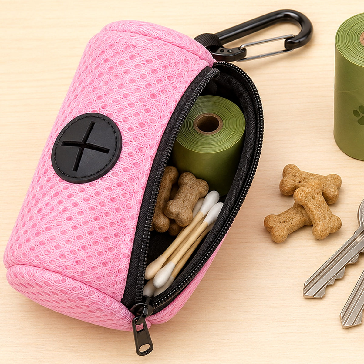 Distributeur ouvert : rouleau de sacs, friandises et petites affaires rangés dans la poche zippée